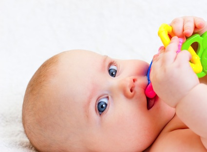 Little baby girl playing with teething toy